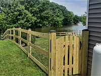 <b>Pressure treated 3-rail ranch rail fence with black mesh and single arched gate</b>